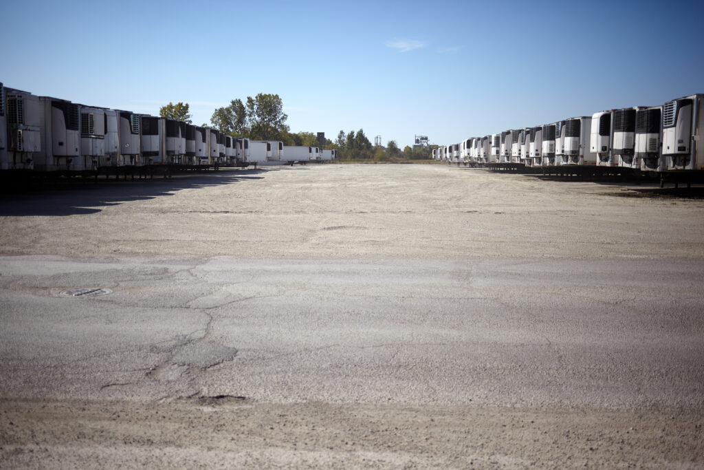 Rows of refrigerated freight trailers parked in a lot at a depot for the distribution of cold products and produce in a receding low angle view